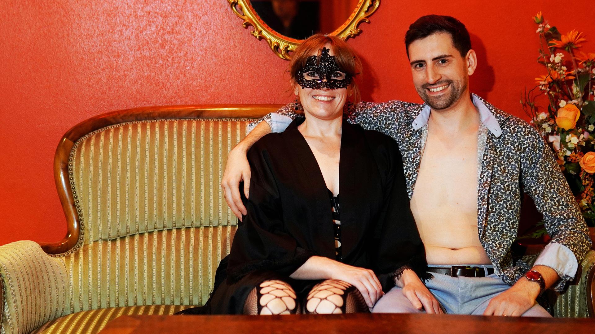 Eine maskierte Frau und ein Mann auf einer Couch