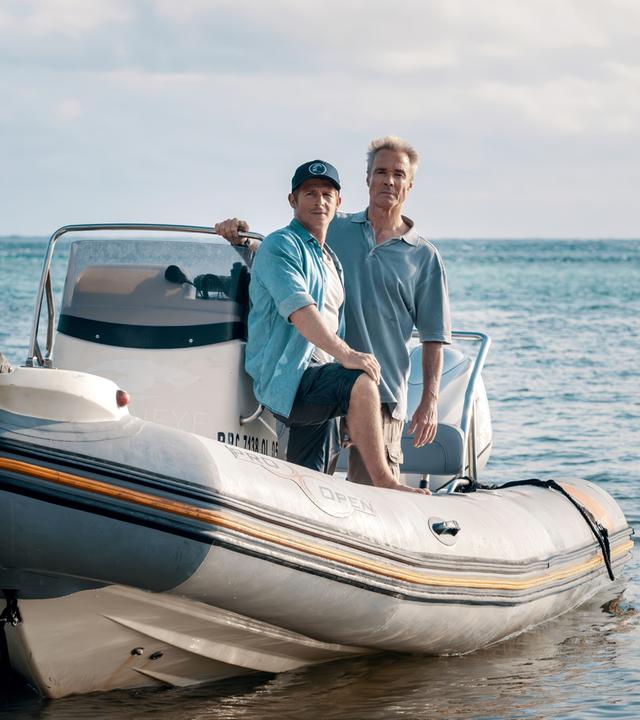 Zwei Männer auf einem Motorboot.