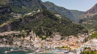 Blick auf Amalfi, im Hintergrund Berge, im Vordergrund das Meer