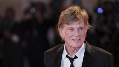 Porträtfoto eines äteren Mannes im Smoking, der lächelt.