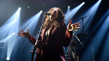 Eine Frau singt in ein Mikrofon.