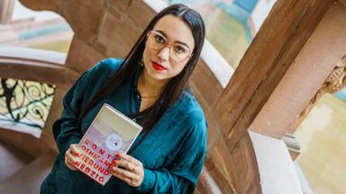 Frau hält Buch in den Händen