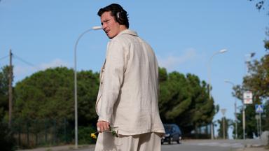 Junger Mann auf Straße schaut sich um.