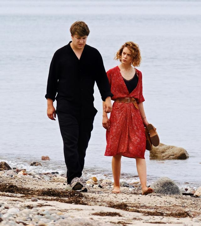 Leon (Thomas Schubert) und Nadja (Paula Beer) laufen nebeneinander am Strand entlang.