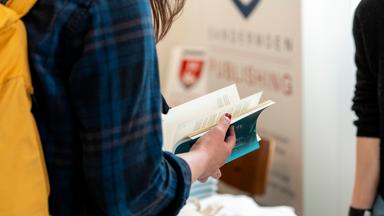 Eine Frau blättert in einem Buch.