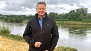 Ein Mann an einem Flussufer.