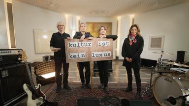 Moderatorin Katty Salié und die Band Tocotronic mit Demoposter "Kultur ist kein Luxus"