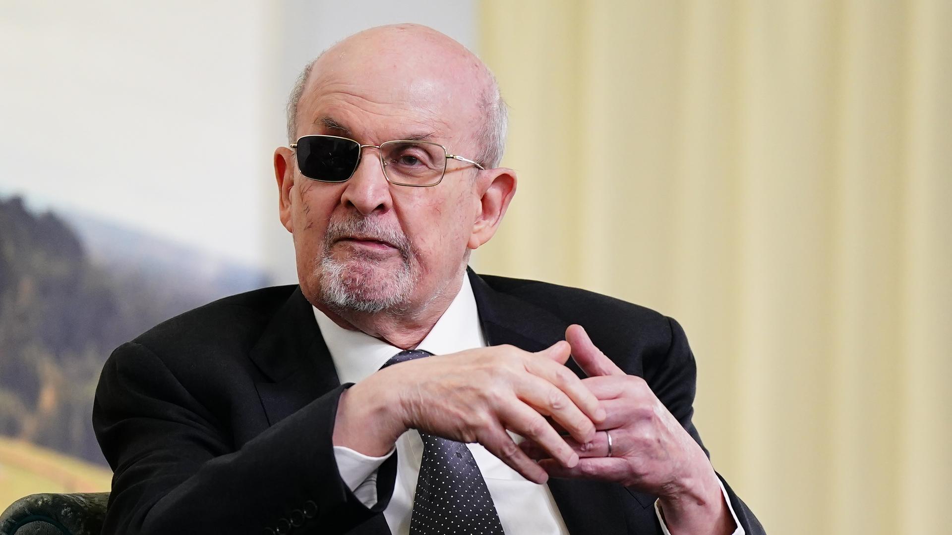 Ein älterer Mann mit graumeliertem Bart und einem geschwärzten Brillenglas.