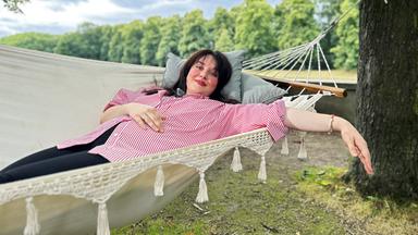 Junge Frau liegt inn der Hängematte