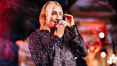 Eine Frau singt in ein Mikrofon. 