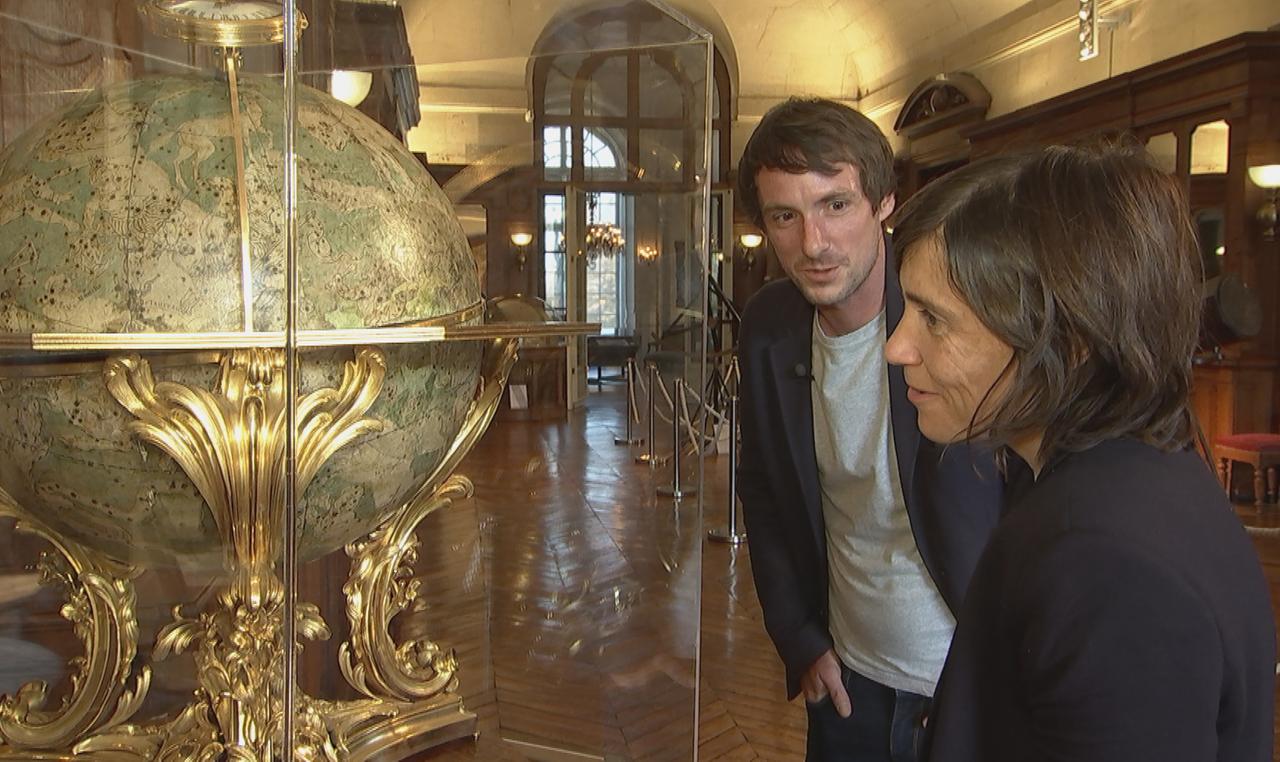 Die beiden Forscher Savoy und Blankenstein vor einem alten Globus