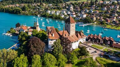 Schloss Spiez umgeben von einem Park an einem Gewässer gelegen 