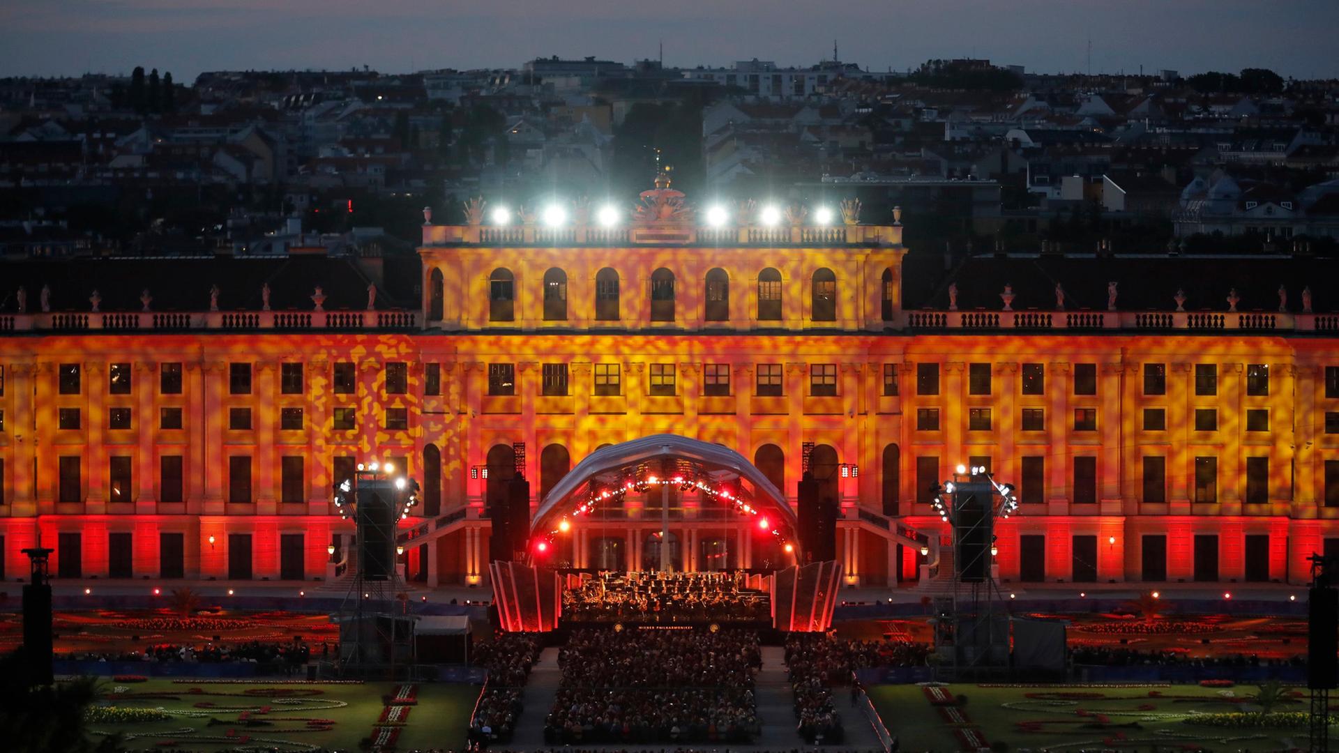 Illuminiertes Schloss Schönbrunn. Die Lichtstimmung ist gelb-orange.