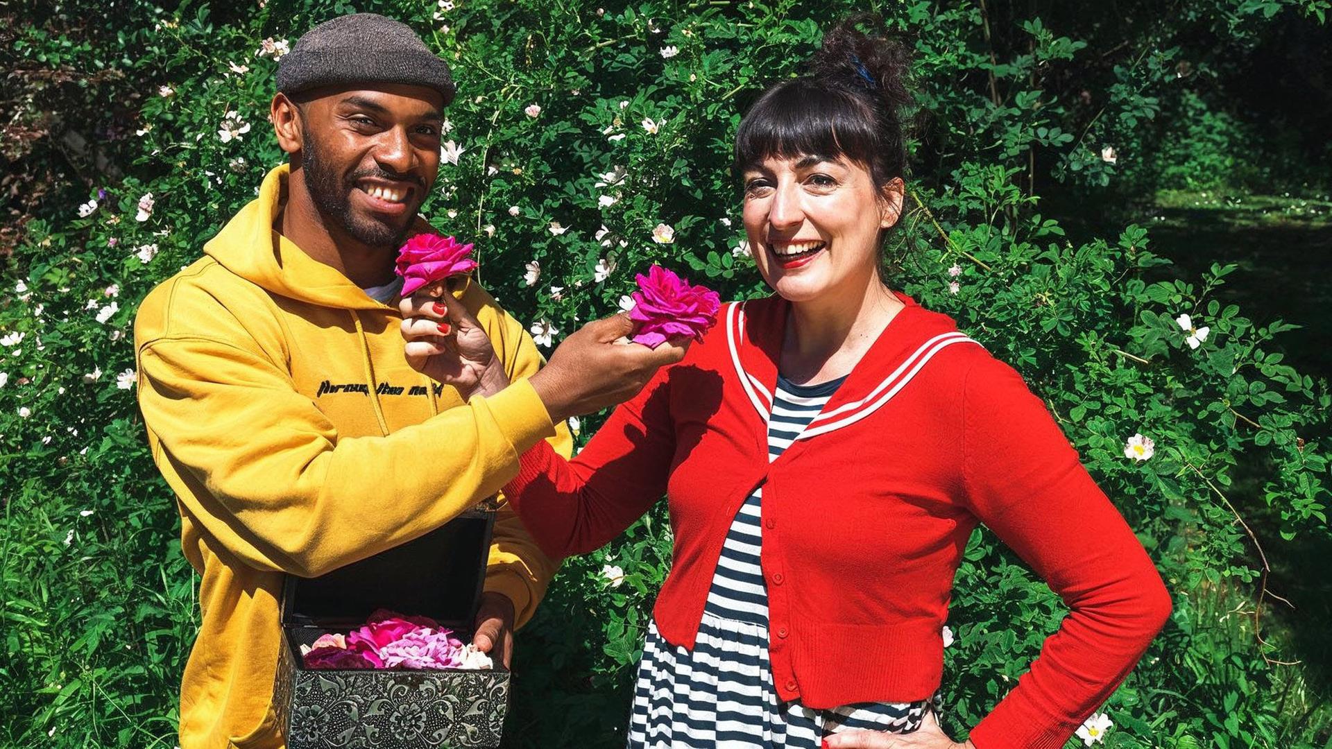 Ein junger Mann und eine junge Frau füttern sich gegenseitig mit Rosenblüten.