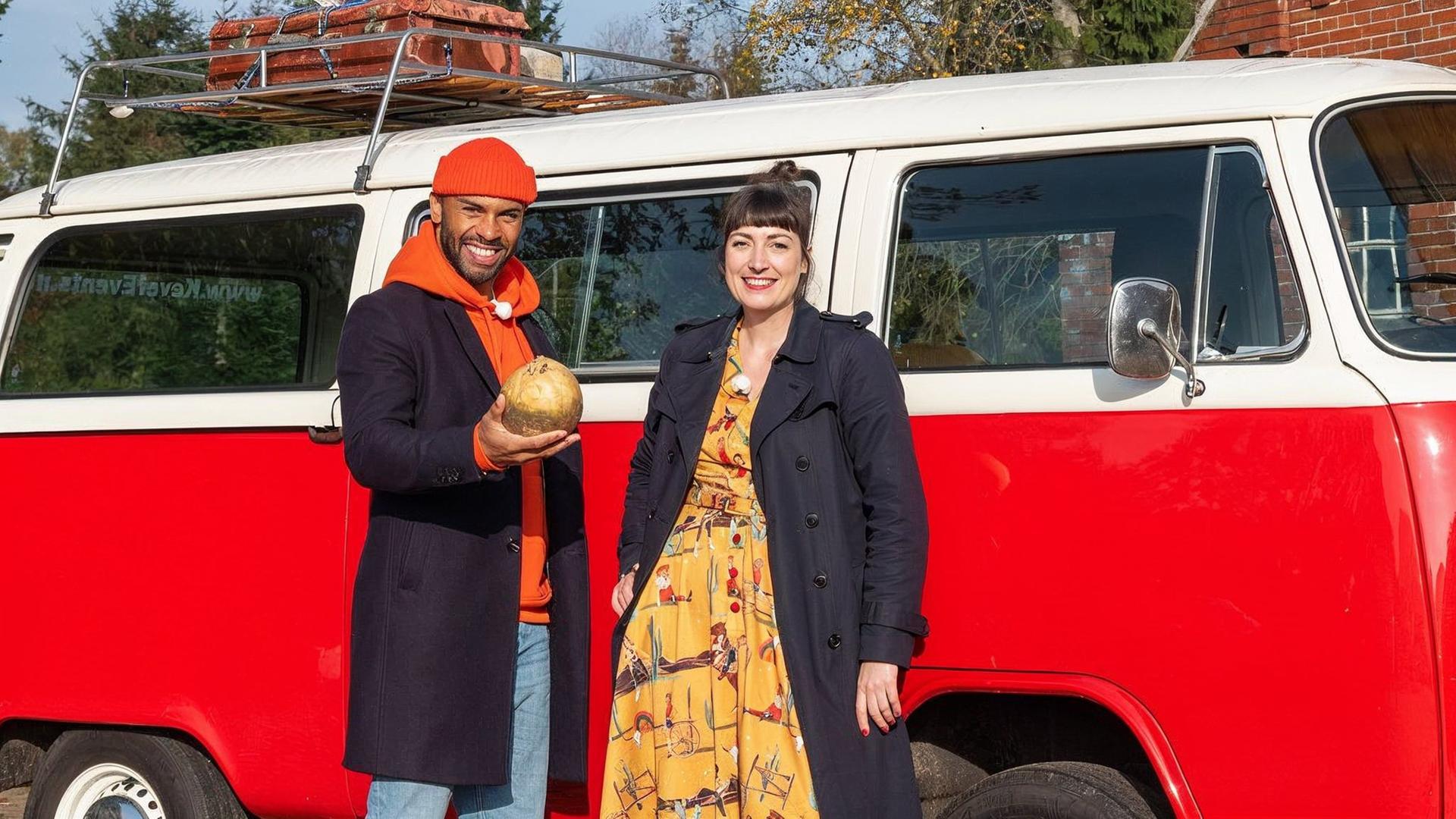 Ein junger Mann und eine junge Frau vor einem alten roten VW Bus.