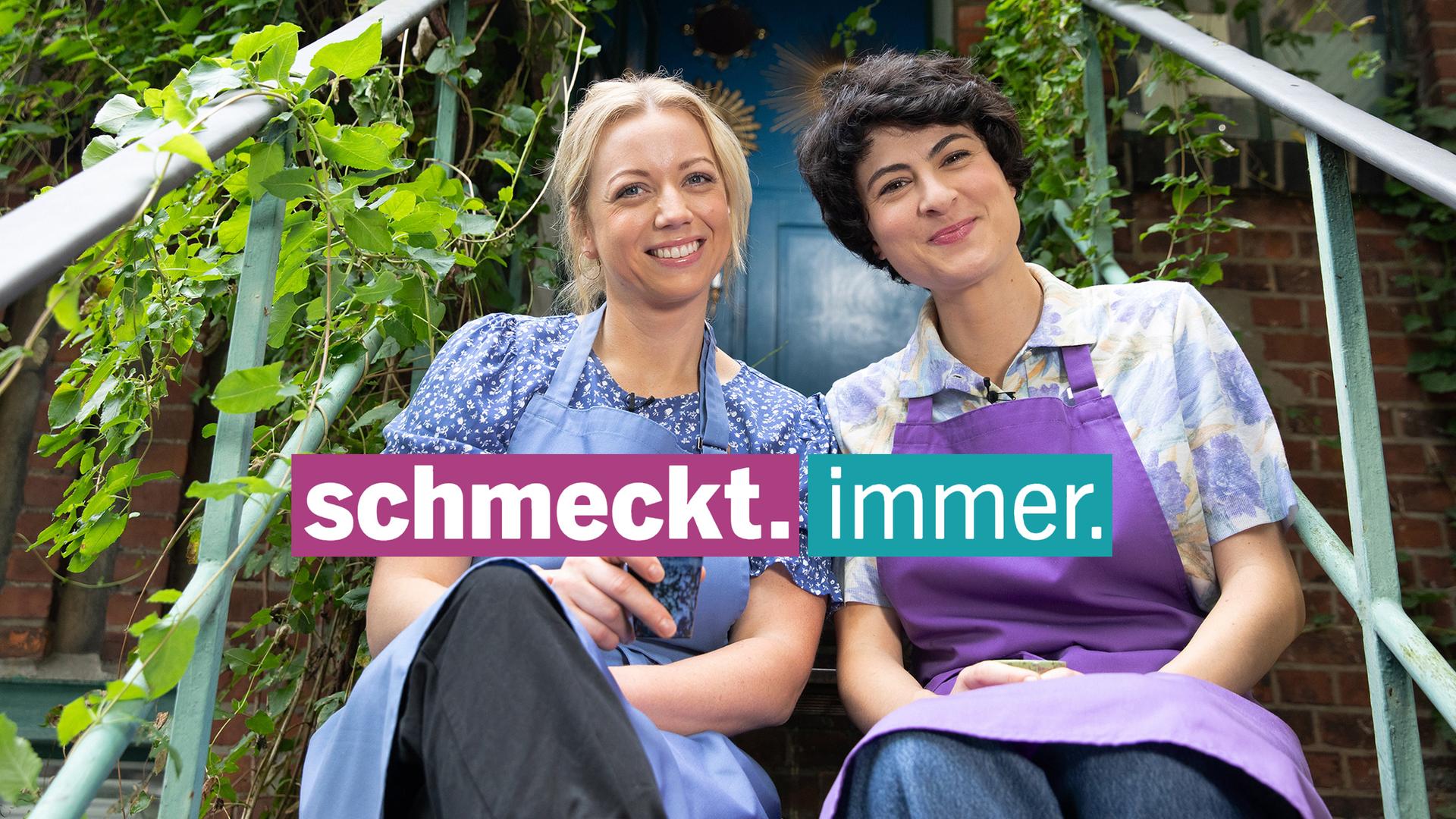 zwei Frauen sitzen auf einer grünumrankten Außentreppe