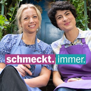 zwei Frauen sitzen auf einer grünumrankten Außentreppe