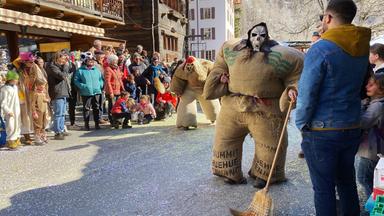 Carnaval d'Evolène, Umzug der Strohmänner. Am letzten Sonntag des Karnevals erwachen Strohriesen zum Leben, die im Dorf ihr Unwesen treiben.