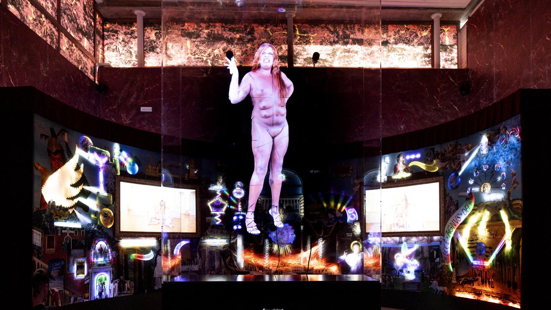 Lebensgroßes Hologramm einer Frau in verdunkeltem Raum mit Videoinstallationen.