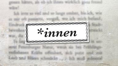 Unscharfer geschriebener Text auf einer Mauer, im Vordergrund das Suffix: *innen