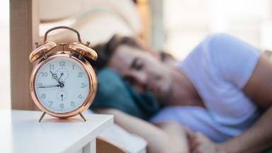 Ein Wecker auf dem Nachtkästchen.