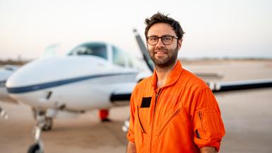 Manos Radisoglou steht vor dem Einsatzflugzeug "Seabird" und lacht in die Kamera.
