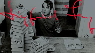 Siegfried Lenz bei einer Signierstunde. Vor ihm stehen mehrere Bücherstapel