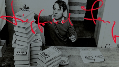 Siegfried Lenz bei einer Signierstunde. Vor ihm stehen mehrere Bücherstapel