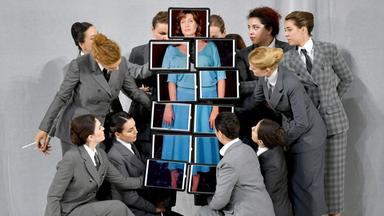 Marina Rebeka (Amelia Grimaldi) sichtbar als eine Montage aus Bildausschnitten, die von mehreren Frauen gehalten werden