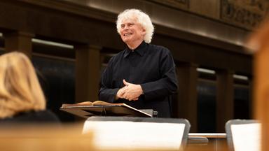 Sir Simon Rattle lächelt bei der Probe