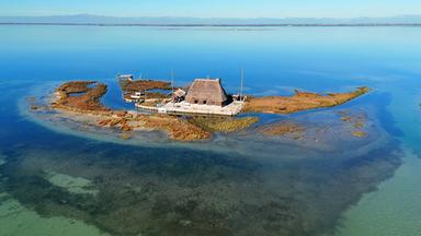 Ein Haus auf einer kleinen Insel von Wasser umgeben