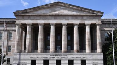 Ein großes historisches Gebäude im antiken griechischen Stil mit hohem Säuleneingang