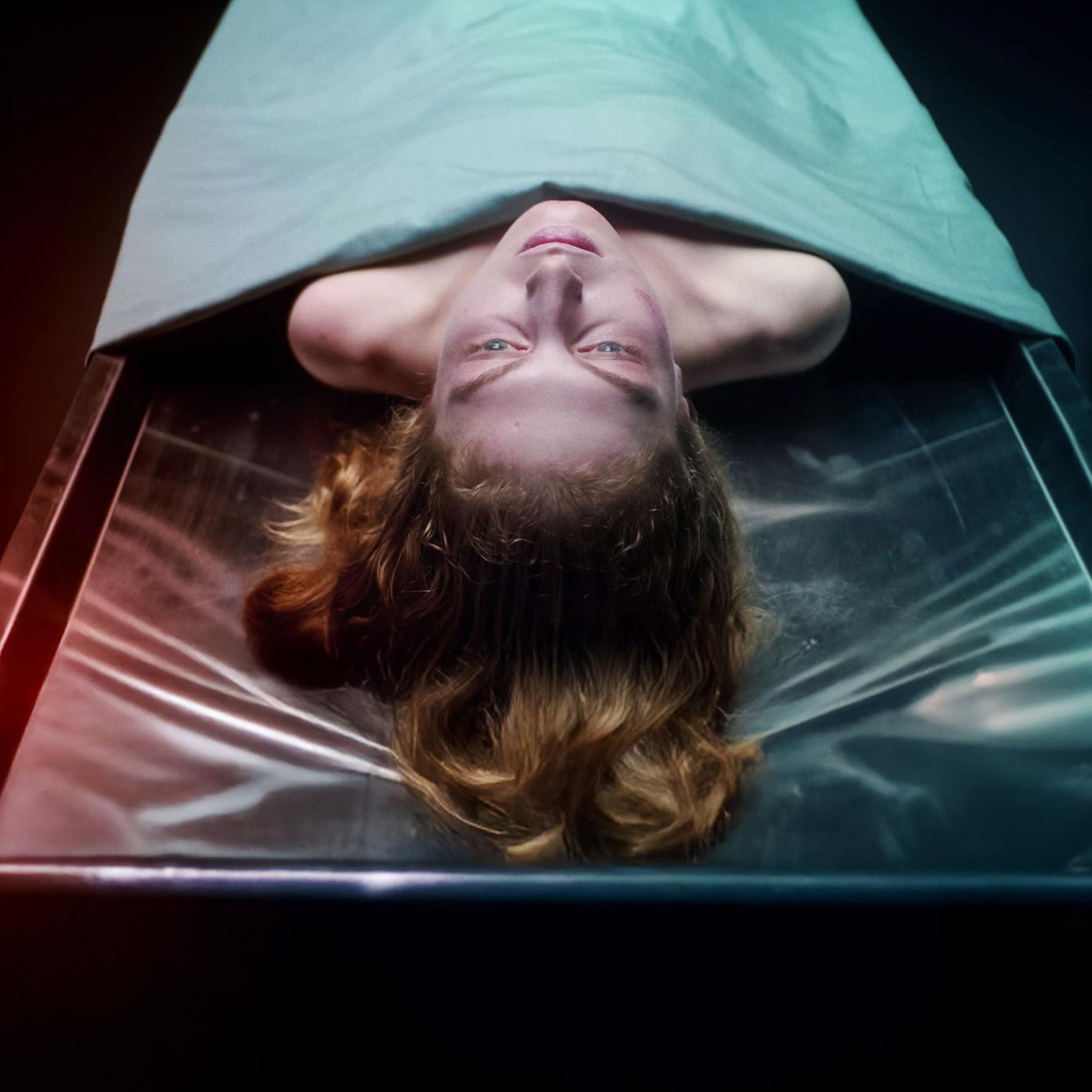 Die Leiche einer Frau liegt auf einem Obduktionstisch. Ihr Kopf und die Schulterpartie ragen unter einem Tuch hervor.