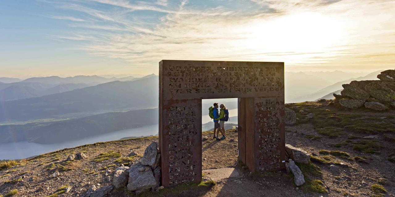 Ein Pärchen ist auf einem Berggipfel unter einem Tor aus Granatsteinen