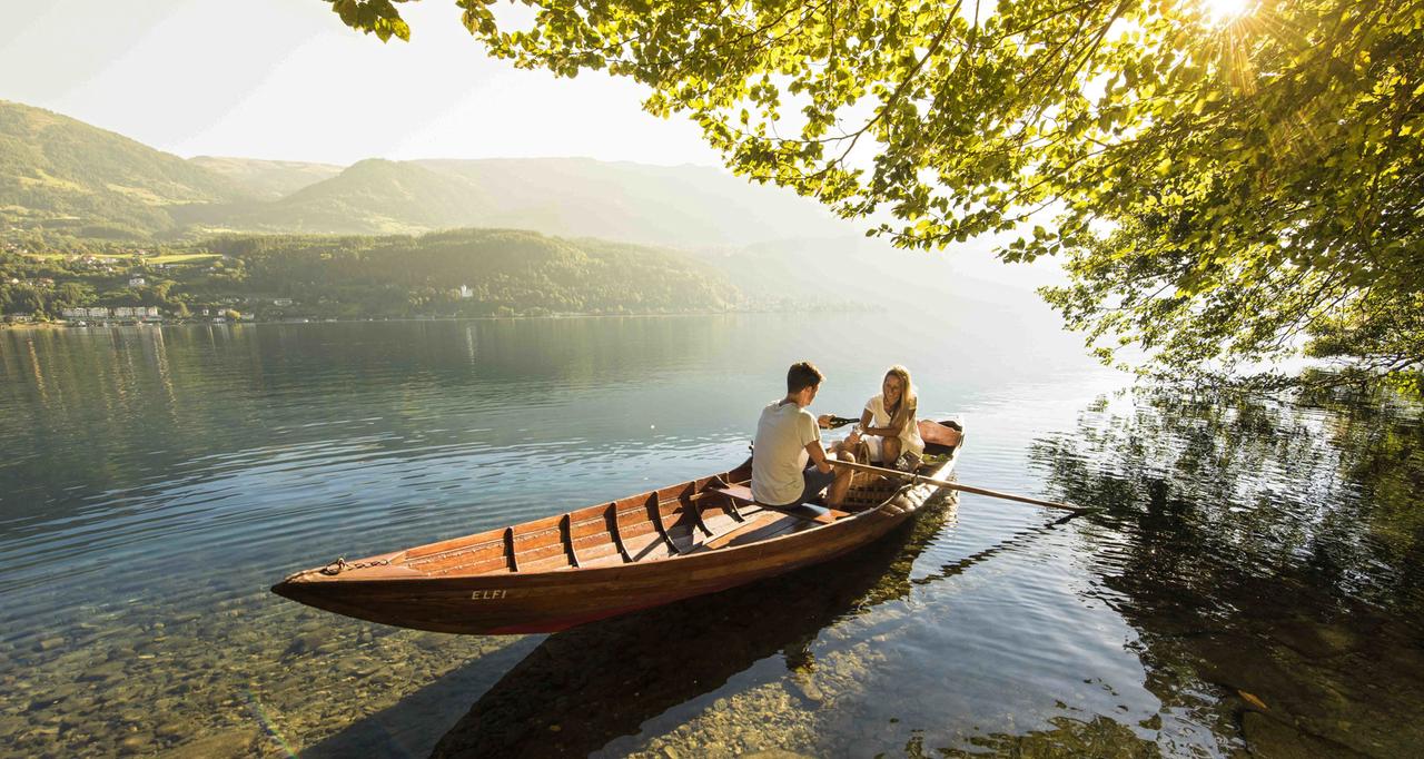 Ein Pärchen paddelt in einem Kanu auf einem See herum.