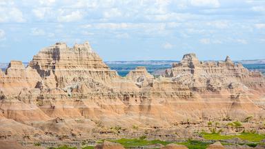 Blick auf die zerklüfteten Felsformationen des Badlands-Nationalparks in South Dakota. Deutlich sichtbare Gesteinsschichten prägen die weite Landschaft.