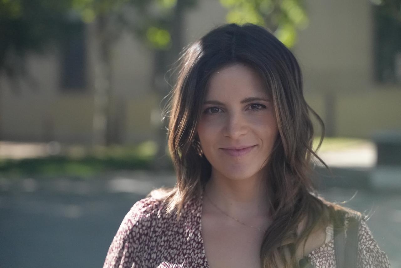 junge Frau mit langen Haaren blickt in Kamera