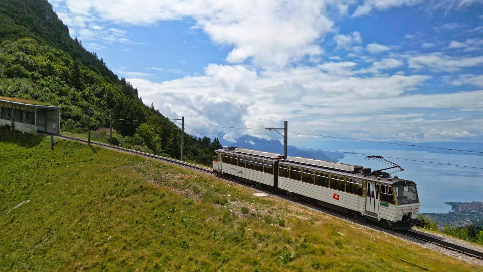 Zug fährt oberhalb des Genfer Sees in die Berge