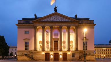Eine Nachtaufnahme der beleuchteten Staatsoper.