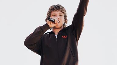 Ein junger Mann singt in ein Mikrofon.