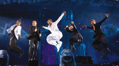 Die Sänger von Take That springen auf der Bühne.