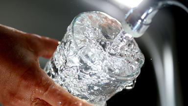 Trinkwasser läuft aus einem Wasserhahn in ein Glas. Archivbild