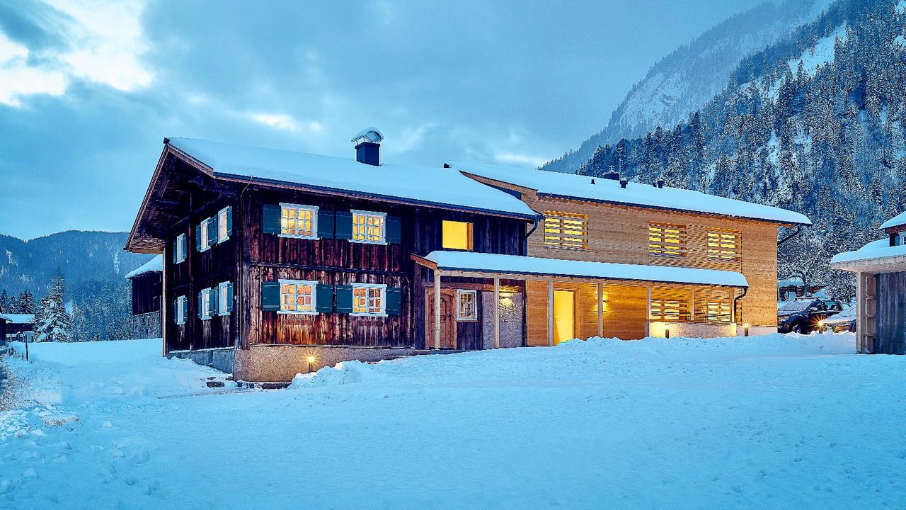 Alte Hütte mit modernem Anbau im Schnee