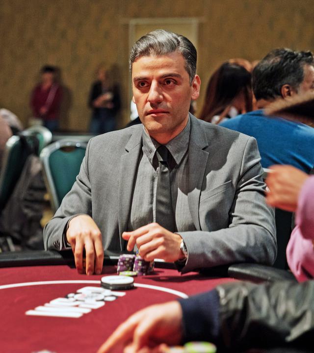 William Tell (Oscar Isaac) sitzt in einem grauen Anzug und Krawatte an einem Pokertisch. Vor ihm liegen zwei Stapel Chips und er schaut konzentriert nach vorn. Um ihn herum sind verschwommen weitere Spieler zu sehen.