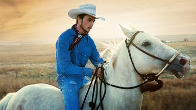 Ein junger Mann auf einem Pferd.