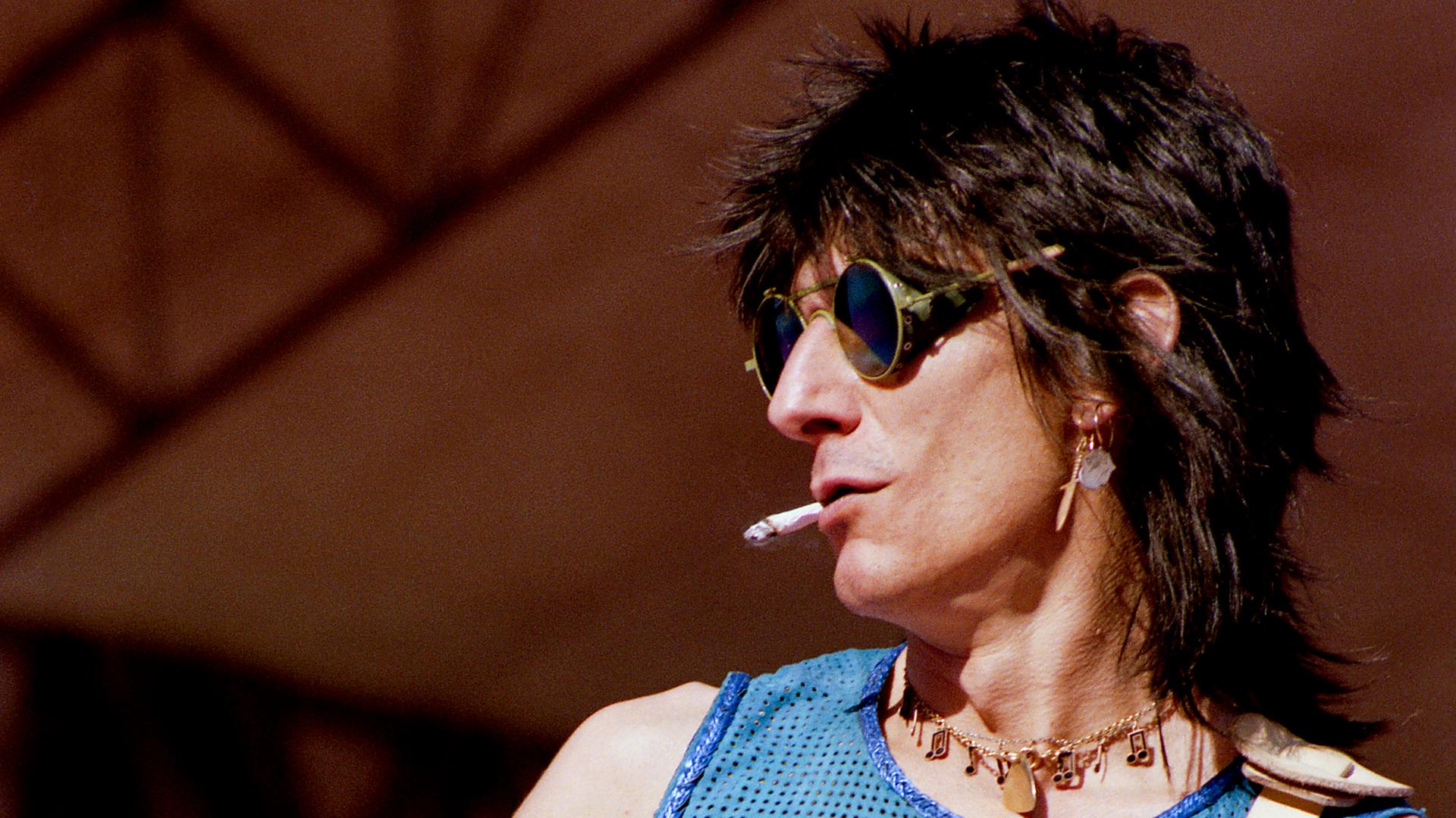 Der junge Gitarrist der Rolling Stones, Ron Wood, in ärmellosem Shirt und mit Zigarette in Aktion