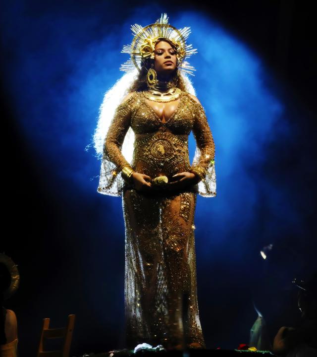 Beyonce tritt bei der Verleihung der 59. Grammy Awards auf. Sie trägt ein durchsichtiges goldenes Kleid und einen kronenartigen goldenen Schmuck auf dem Kopf.