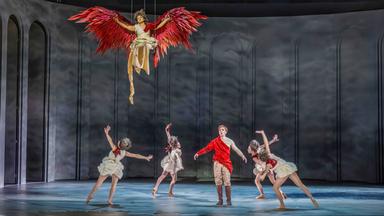 Bühnenszene: Fün Personen tanzen auf der Bühne. Ein Engel schwebt über ihnen.