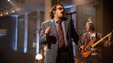 Der Sänger der Band Tiavo singt in ein Mikrofon.