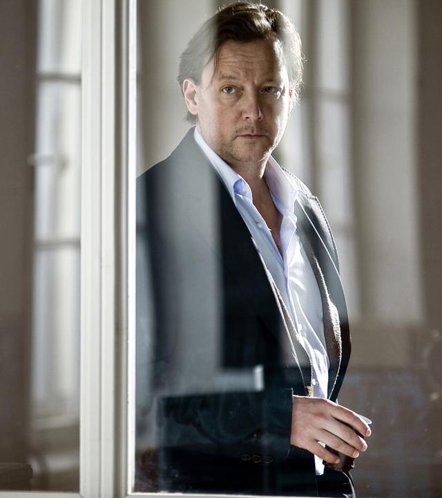 Alex (Mathias Brandt) sieht durch die Scheibe dem Verhör seiner Kollegin zu.